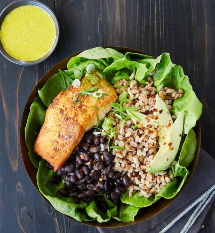 Farro, black beans, and tahini in a salmon bowl